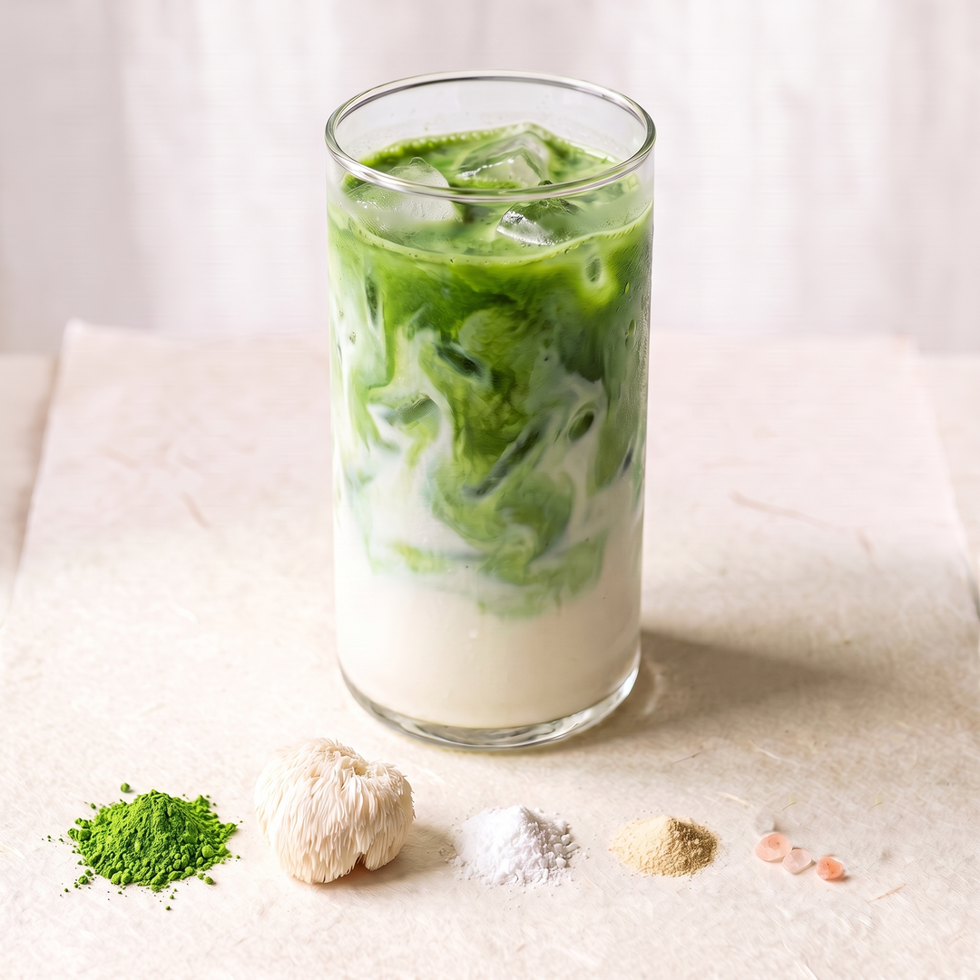 An iced matcha latte with a few ingredients in front of it.